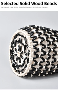 Detail showing intricate black and white wooden beads woven on a handmade bucket bag