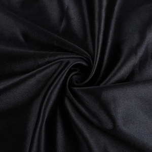 Gros plan détaillé de la texture satinée noire et du drapé fluide de la robe en soie