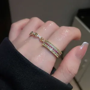 Anello a catena vuota placcato oro con zirconi rosa e bianchi su dito di donna