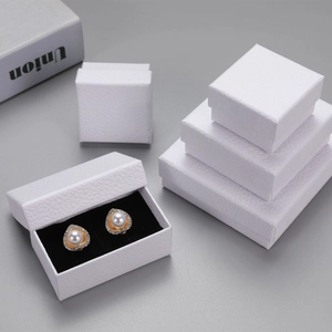 Detailed view of white litchi textured jewelry boxes with pearl earrings inside