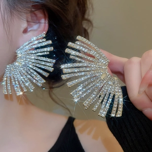 Detailed close-up of large fan-shaped rhinestone stud earrings with sparkling silver rays