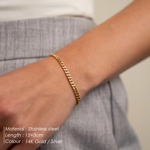 Detailed close-up of a 14K gold and silver stainless steel chain bracelet on a wrist