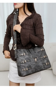Detail of distressed PU leather texture with metal eyelets and buckles on crossbody bag