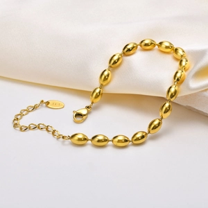 Detail of 18K gold stainless steel olive bead bracelet with lobster clasp on white silk