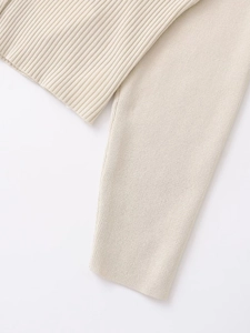 Detailed close-up of cream knit cardigan featuring ribbed and flat stitch texture contrast
