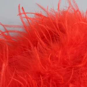 Macro shot of vibrant red ostrich feather trim detailing on an off-shoulder dress