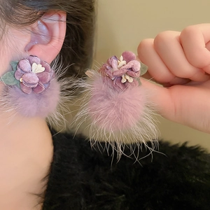 Detailed view of purple velvet flower earrings with fluffy pom-pom pendants for women