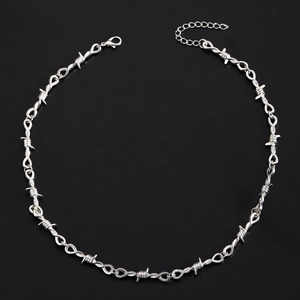 Detail of gothic silver metal necklace with heart rose and barbed wire design