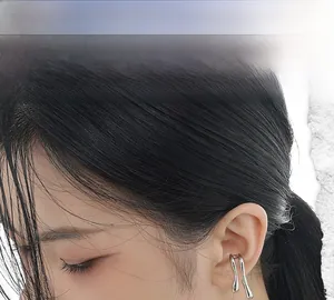 Detail of irregular liquid-style silver ear cuff for non-pierced ears on a model