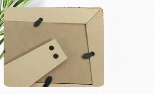 Détail du dos du cadre photo en MDF montrant les clips pivotants noirs et le support robuste