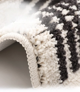 Macro detail of plush black and white striped bathroom mat with thick absorbent fibers