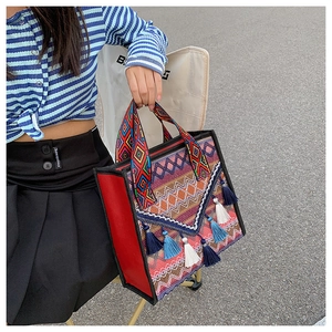 Detailed embroidery with colorful ethnic patterns and long cotton tassels on a tote bag