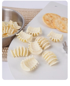Dettaglio di rotoli di patate alle verdure con condimento su tovaglietta tessuta