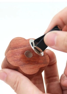 Gros plan de l'installation d'un clip d'aération dans un diffuseur d'huiles essentielles en bois