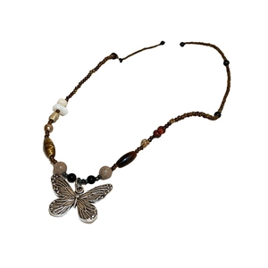 Ethnic butterfly pendant necklace featuring dark brown and beige beads on a minimalist string