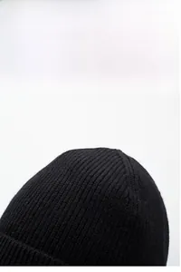 Detailed view of the black ribbed knit pattern and thick elastic wool texture on the beanie