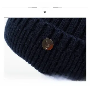 Detailed macro view of dark blue knit winter hat texture with silver metal logo tag