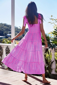 Detail of smocked back and adjustable tie shoulder straps on pink tiered maxi dress