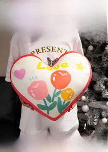 Close-up of heart-shaped plush pillow with Love lettering and floral pattern