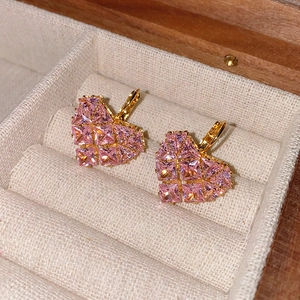Gros plan de boucles d'oreilles cœur en zircon rose doré dans un écrin de velours
