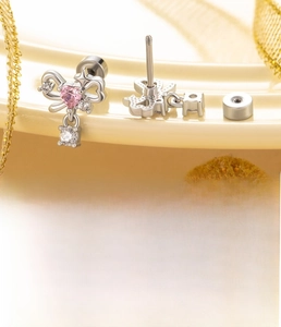 Detail of bow-shaped screw back earring with pink heart zircon and polished steel post