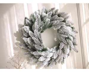 Detail of green pine Christmas wreath with realistic white frost and golden branch accents