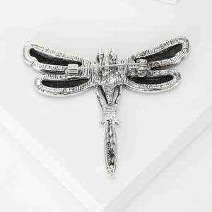 Vintage silver dragonfly brooch showing back pin closure and detailed metal texture
