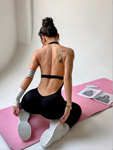 Seamless backless one-piece yoga bodysuit with halter neck in sleek black fabric