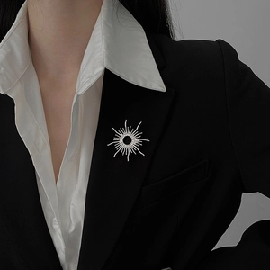 Silver 18k plated sunburst brooch with zircons pinned on a black tailored blazer lapel