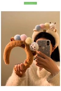 Detailed view of brown and cream plush headbands with colorful pompoms and cute charms