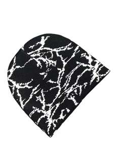 Close-up of black knitted beanie with white branch pattern for street style fashion