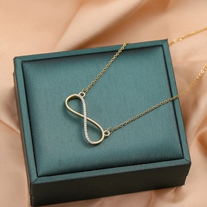 Elegant gold infinity symbol necklace with micro-pave crystals on a silk backdrop