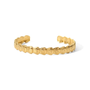 Détail d'un bracelet jonc en acier plaqué or 18 carats avec texture de coquillage