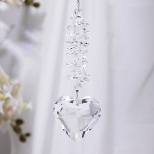 Macro detail of faceted heart-shaped crystal suncatcher hanging with prism beads