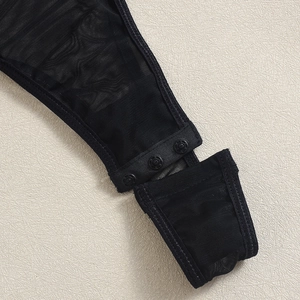 Close-up of black mesh bodysuit with three-snap button closure and fine fiber texture