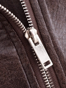 Macro shot of silver metal zipper and dark brown PU leather texture on a jacket