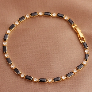 Detail of gold bracelet with rectangular black gems and round clear cubic zirconia stones