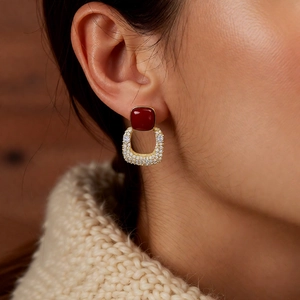 Détail de boucle d'oreille vintage carrée plaquée or 18K avec pierre rouge