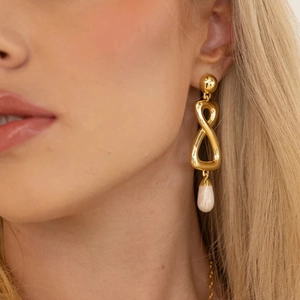 Boucles d'oreilles dorées forme infini avec perles en goutte d'eau sur le mannequin