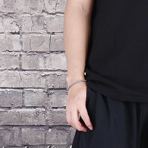 Close-up of a masculine silver stainless steel multi-link chain bracelet on a male wrist