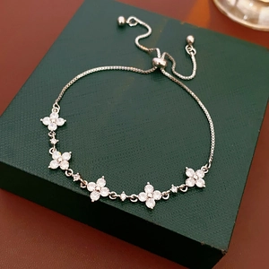 Detail eines verstellbaren Silber-Kleeblatt-Armbands mit Zirkonia auf grüner Box