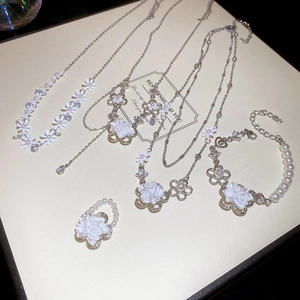 Detailed set of floral pearl necklaces and bracelets displayed on an elegant jewelry box
