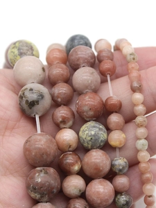 Macro shot of natural Plum Blossom Jade beads showing various colors and textures for jewelry