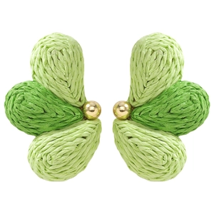Detail of green raffia woven earrings with golden bead center and intricate craft textures