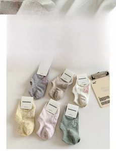 Flat lay of six-color combed cotton ankle socks with embroidery detail and branding