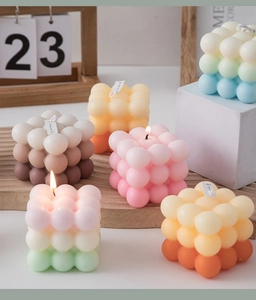 Detailed view of lit gradient bubble cube candles with soft textures for home decor