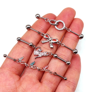 Détail de 4 piercings industriel barbell avec motifs de nœud, chat et papillons