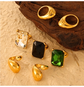 Detail of gold-plated rings with rectangular gems and smooth water drop designs