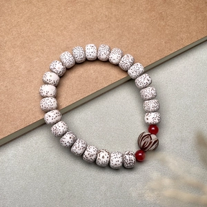 Detail of Xingyue Bodhi beads with a dark brown carved lotus mother bead and red accents