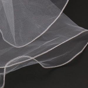 Detail shot of white bridal veil showing high-quality mesh texture and stitched edges